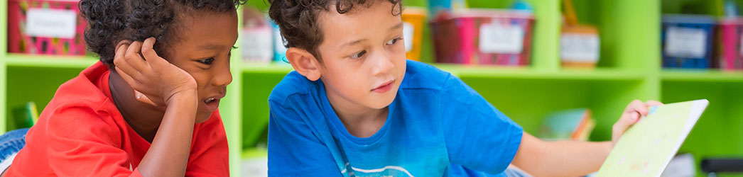 Deux garçons de la maternelle qui lient un livre ensemble.
